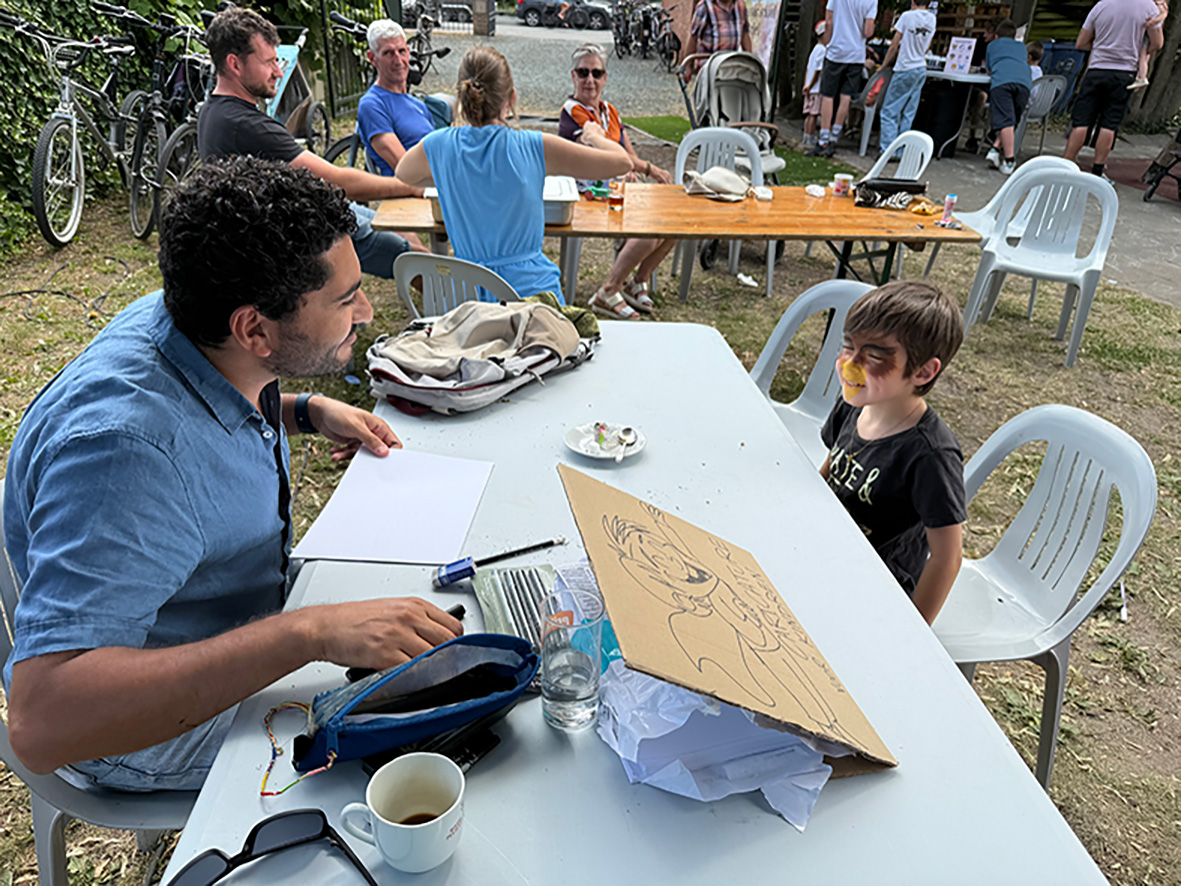 Live caricature artist Sameh Samir drawing for a child at a school event in Buggenhout Belgium