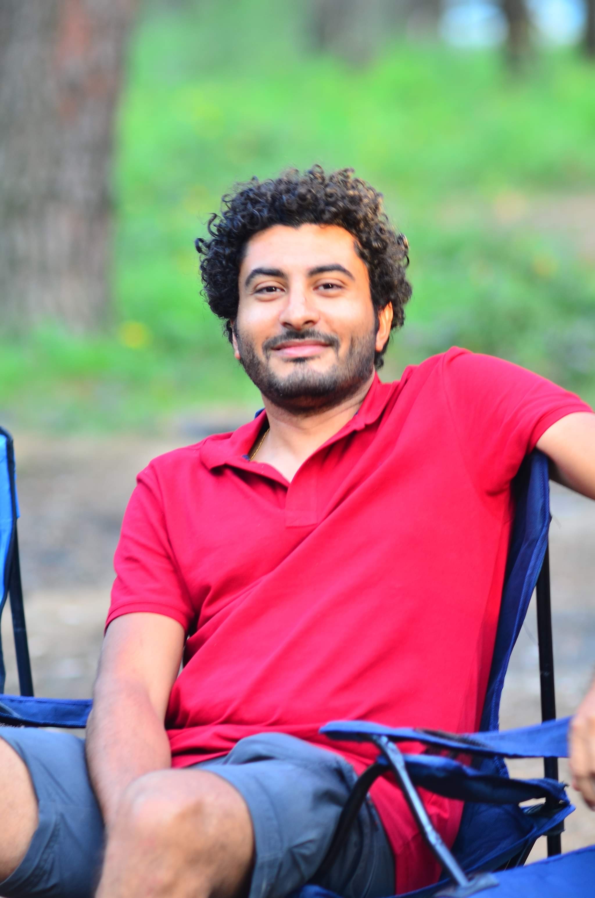 Sameh Samir sitting in the forests of Istanbul wearing a red shirt