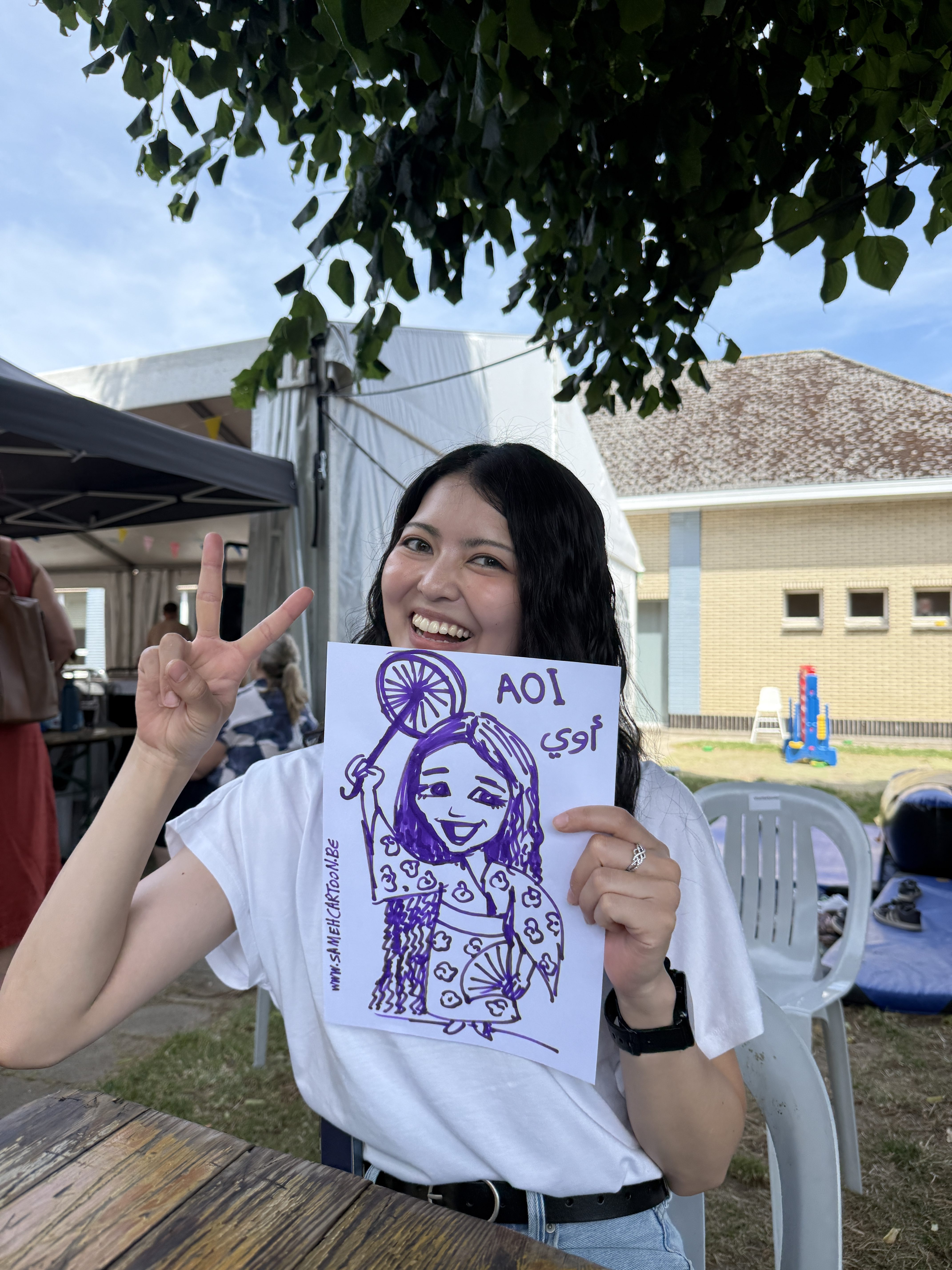 Guest posing with a finished cartoon portrait at a live event